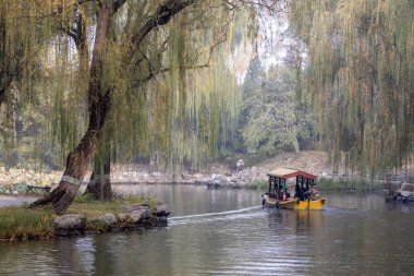 Pekin, Çin - 3 Kasım 2024: Pekin, Çin 'deki Yuanmingyuan Parkı' nda turistler için tekne turu. Çin tarihinin en muhteşem ve lüks imparatorluk bahçesiydi.