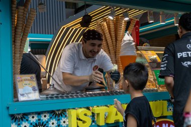 Kuala Lumpur, Malezya - 23 Aralık 2024: Dondurma veya Türkçe dondurma satıcısı, Malezya 'nın Bukit Bintang kentindeki bir sokak dükkanında çocuklara muhteşem bir gösteri yapıyor
