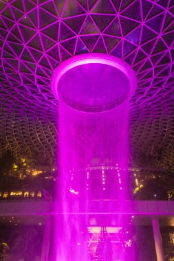 Singapur - 31 Ekim 2024: Aydınlanmış adam Singapur 'daki Jewel Changi' de şelale yaptı. Jewel Changi, Changi Havaalanı Terminali 'ne doğrudan bağlı bir alışveriş merkezidir.