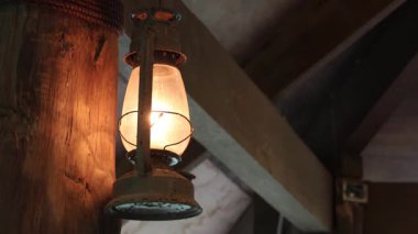 Bir evin karanlık odasında eski bir lamba.