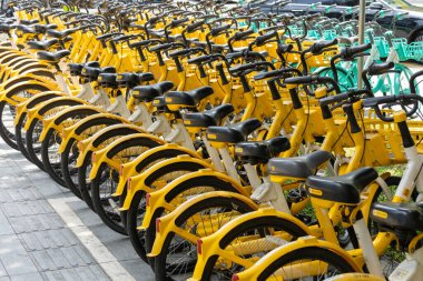 Shenzhen, Çin - 10 Nisan 2025: Shenzhen, Çin 'de yol kenarında ortak bisiklet parkı. Bisiklet Çin 'de şehri dolaşmak için yaygın bir yoldur..