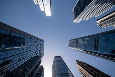 Shenzhen, Çin - 15 Nisan 2025: Shenzhen, Çin 'de mavi gökyüzü olan yüksek katlı ofis binası. Şehir 1979 yılında özel bir ekonomik bölge haline geldi ve hızla yabancı yatırım ve teknoloji ile büyüdü.