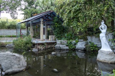 Shenzhen, Çin - 14 Nisan 2025 Shenzhen Uluslararası Bahçe ve Çiçek Fuarı Parkı, Shenzhen, Çin. Parkta zengin çiçek manzaralı geleneksel Çin mimari tarzları yer alıyor.