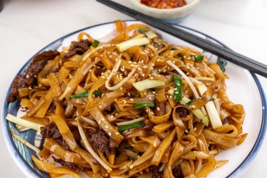 Kızarmış pirinç şehriyesini bir tabakta sığır etiyle karıştır. Kanton usulü mutfak 