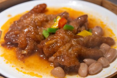 Bambu buharlı bir buharlı tencerede servis edilen kavurmalı tavuk budu.