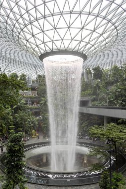 Singapur - 8 Nisan 2025: Dünyanın en uzun kapalı şelalesi, Yağmur Girdabı, Changi Jewel, Singapur 'da bir teras ormanı ile çevrili..