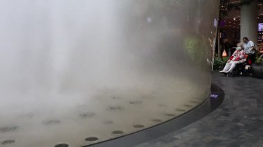 Singapur - 8 Nisan 2025: Dünyanın en uzun kapalı şelalesi, Yağmur Girdabı, Changi Jewel, Singapur 'da bir teras ormanı ile çevrili..