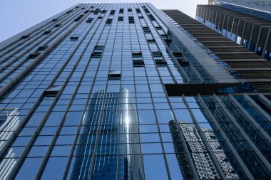 Shenzhen, Çin 'deki mavi penceredeki yüksek katlı bir ofis binasının yansıması..