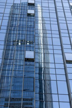 Shenzhen, Çin 'deki mavi penceredeki yüksek katlı bir ofis binasının yansıması..