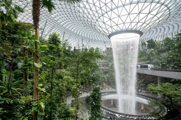 Singapur - 8 Nisan 2025: Dünyanın en uzun kapalı şelalesi, Yağmur Girdabı, Changi Jewel, Singapur 'da bir teras ormanı ile çevrili..