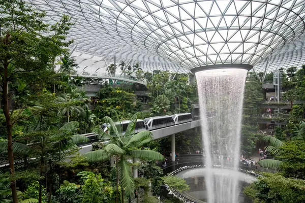Singapur - 8 Nisan 2025: Dünyanın en uzun kapalı şelalesi, Yağmur Girdabı, Changi Jewel, Singapur 'da bir teras ormanı ile çevrili..