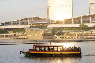 Singapur-4 Haziran 2025: Bir turist teknesi akşamleyin Singapur 'daki Marina Körfezi' nde denize açılır. Marina Körfezi Sands Singapur 'daki en ikonik binadır.