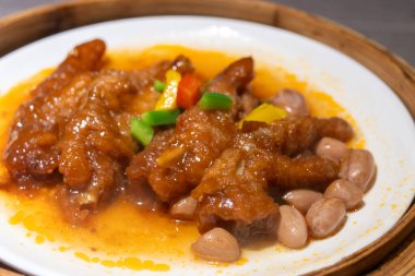 Bambu buharlı bir buharlı tencerede servis edilen kavurmalı tavuk budu.