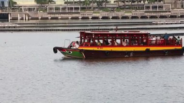 Singapur-4 Haziran 2025: Bir turist teknesi akşamleyin Singapur 'daki Marina Körfezi' nde denize açılır. Marina Körfezi Sands Singapur 'daki en ikonik binadır.