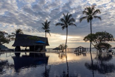 Havuzda gökyüzünün yansıması olan bir otelde gün doğumu..