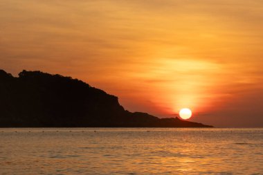 Malezya, Redang Adası 'nda nefes kesen gün doğumu. Parlak güneş ışığı ve renkli gökyüzü, doğal güzelliği arttırıyor.