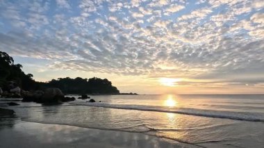 Sabah Kuantan, Malezya 'daki Teluk Cempedak plajında. Bir sürü insan sahilde sabah yürüyüşü yapıyor.