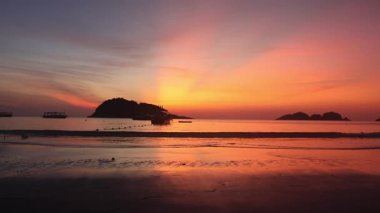 Malezya, Redang Adası 'nda nefes kesen gün doğumu. Parlak güneş ışığı ve renkli gökyüzü, doğal güzelliği arttırıyor.