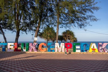 Kuantan, Malezya - 16 Haziran 2025: Kuantan, Malezya 'daki Teluk Cempedak plajının renkli işareti. Kıyı şeridi yumuşak beyaz kum tabakalarıyla kaplanmış güzel bir körfez.