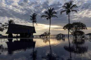 Havuzda gökyüzünün yansıması olan bir otelde gün doğumu..