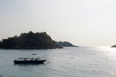 Redang Adası, Malezya - 15 Haziran 2025: Beyaz kumlu kristal berrak suyla Redang Adası kıyısında küçük tekne parkları