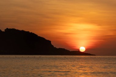 Malezya, Redang Adası 'nda nefes kesen gün doğumu. Parlak güneş ışığı ve renkli gökyüzü, doğal güzelliği arttırıyor.