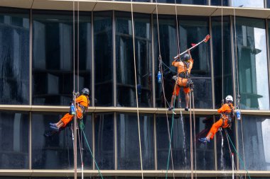 Singapore- 27 Sep 2025: Workers are cleaning the glass wall of an office building in Singapore