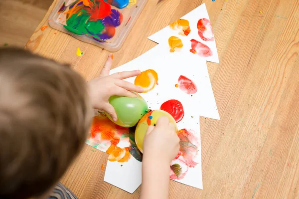 Painting Christmas tree. Occupational therapy, ergo therapy, calming activities. Painting with balloons. Hand stimulation, freedom of creativity. Montessori method for kindergarten and preschool.