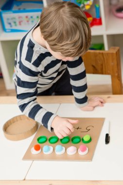 Plastik şişe kapakları. Doğru miktarda ponponu kupalara koy, matematiksel denklemi tamamla. Beş dakikalık el işi. Çocuk yuvası aktivitesi. Erken eğitim, sayma oyunu, iyi motor becerileri..