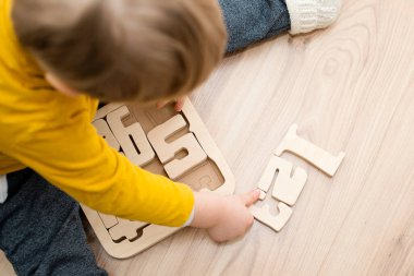 Bulmaca numaraları. Çocuk ahşap numaralarla oynuyor. Erken eğitim, sözlü ve hafıza oyunu.
