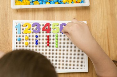 İğne yerleştiren numaracı çocuk sayesinde. Evde oyna. Çocukların iyi motor becerileri geliştirmesi için uygulama, oyun yoluyla mantıklı düşünme. Saymayı öğren ve hayal gücünü, yaratıcılığı canlandır..