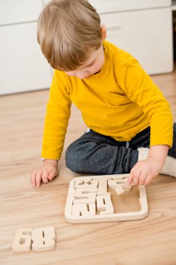 Bulmaca numaraları. Çocuk ahşap numaralarla oynuyor. Erken eğitim, sözlü ve hafıza oyunu.