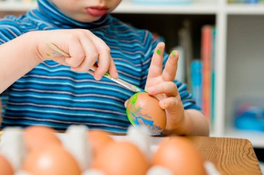 Mutlu Paskalyalar. Paskalya yumurtası boyayan 3 yaşında bir çocuk. Dini bayram. Erken eğitim ve sanatsal anaokulu aktiviteleri.