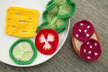 Sosis, salata, peynir, salatalık ve domatesli el yapımı tığ işi sandviç. Sağlıklı kahvaltı, anaokulu çocukları için mutfak oyuncakları. Evde çocukların hayal gücünü geliştirmek için duyusal pişirme oyunları..