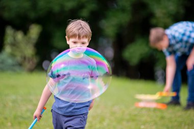 Yaz tatili. Okullar kapalı. Parkta sabun köpüğüyle oynayan iki kardeş. Neşeli mutlu aile piknik yapıyor. Tatiller ve doğa seyahatleri..