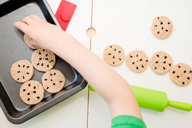 Çikolata parçacıklı el yapımı örgü kurabiyeler. Lezzetli yemek, tatlı aperatif. Küçük çocuklar için mutfak oyuncakları. Evde duyusal pişirme oyunları. Çocukların hayal gücünün gelişimi. Meslek rolleri.