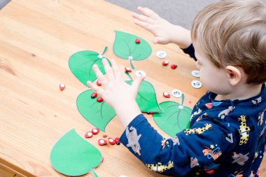 Uğur böceğinin miktarını belirlenmiş ağaç yaprağına yaz. Bebek sayma oyunu oynuyor. Anaokulları için anaokulu eğitimi yardımı. Çocuklar zeka ve gelişim için montessori setini erken öğreniyor