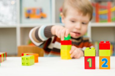 Saymayı öğreniyorum. Duplo bloklarını istifleyen 2 yaşında bir çocuk. Çocuklar, bebeklik ve eğitim konsepti. Çocuğun oluşumu ve gelişimi. Montessori ve erken gelişim