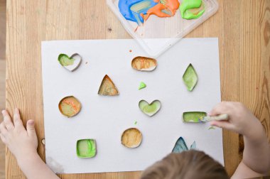 Çocuk geometrik şekilleri öğreniyor. Güzel motor beceriler. Anaokulu ya da özel görevler. Çocukların erken eğitimi. Montessori yöntembilimi.