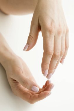 Kadının elleri bir şey tutuyor gibi. Yardım etmeye ya da kabul etmeye hazırım. Beyaz arka planda izole hareket. Kurtarmak için yardım eli uzatılır. Fransız manikürüyle süslenmiş..