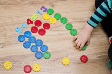 Matematik ve eğlence. Renkli doğal ahşap ile büyük düğmeleri saymak ve işaretlemek. Oyun bitti. Evde oyna. Öğrenme metodu. Erken eğitim, sayma oyunu, iyi motor beceriler..