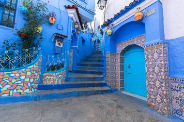 A blue street of Chefchaouen with quiet atmosphere and beautiful contrat with flowers and pot