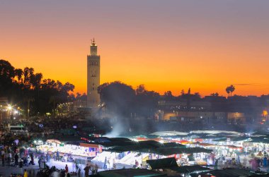 jemaa el Fna at sunset. The night is coming and the city life is starting in the market.