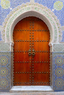 Fes, Morocco Stunning hand painted door of an old mosque with hand carved plaster work. clipart
