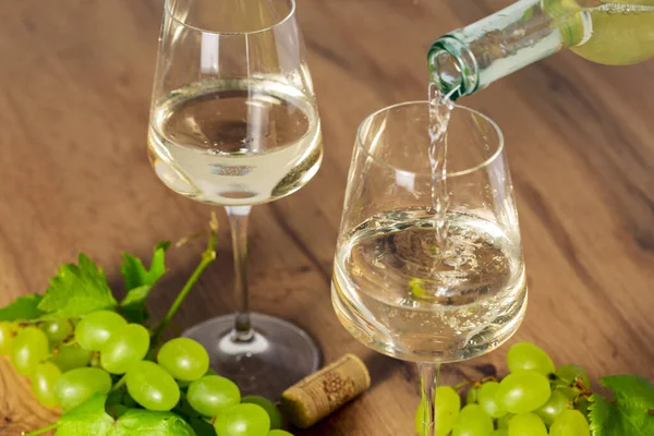 白ワインを秋のブドウ 古い木の背景 選択的な焦点でゴブレットに注ぐ — ストック写真