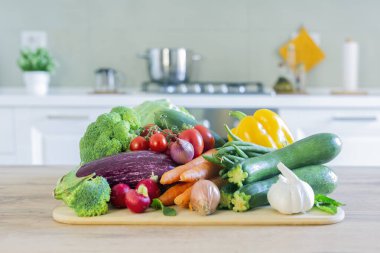 Sofrada sebzeleri olan şık, modern bir mutfak. Parlak beyaz mutfak ve ev eşyaları. Sağlıklı yaşam tarzı kavramı.