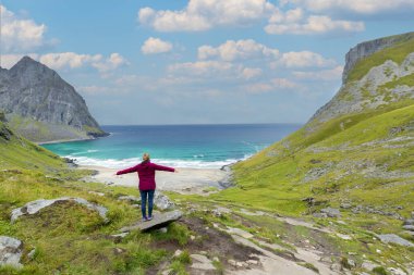 Norveç, Lofoten 'deki Kvalvika Sahili' ne bakan maceracı kadın.