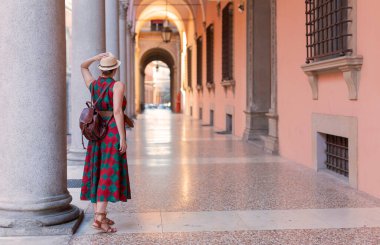 İtalya 'nın Bologna şehrindeki ünlü kemerli galerilerinde gelişigüzel giyinmiş genç bir turist. Bologna dünyanın en eski üniversitesine ev sahipliği yapar.