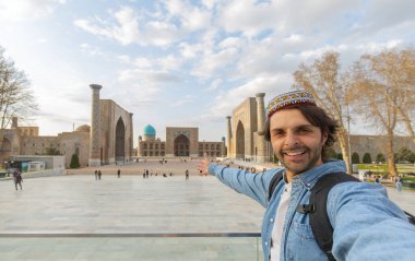 Mutlu turistler Semerkant 'ta Registan' la fotoğraf çektirip Özbekistan, Orta Asya 'ya seyahat ediyorlar.