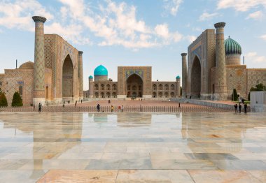 Özbekistan, Semerkant 'taki Registan Meydanı' nın muhteşem manzarası. Ulugh Beg Madrasah ve Sher-Dor Madrasah ıslak zemine yansıdı. Sicil, Orta Asya 'nın popüler bir turistik merkezidir..